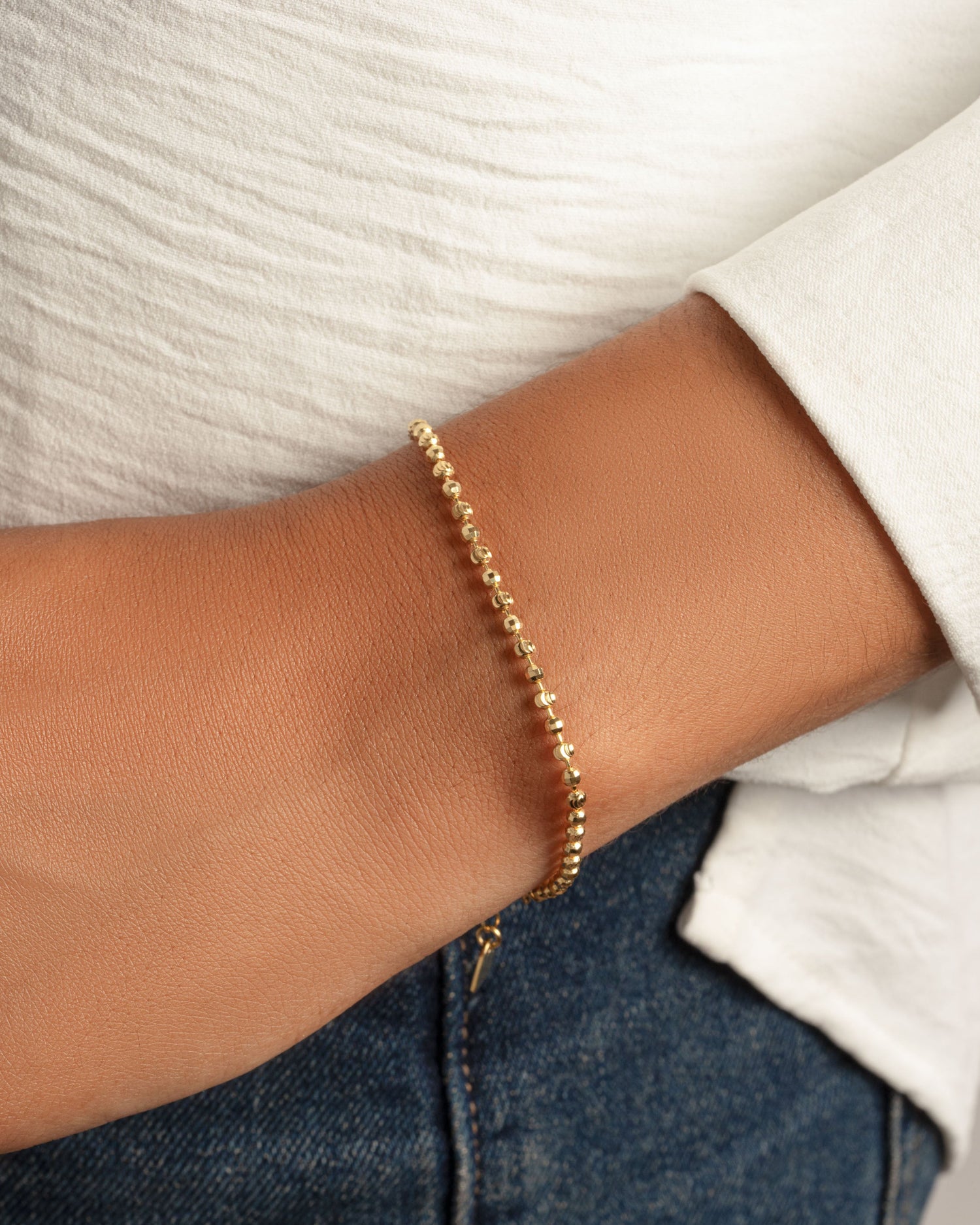 Gold beaded bracelet on model 