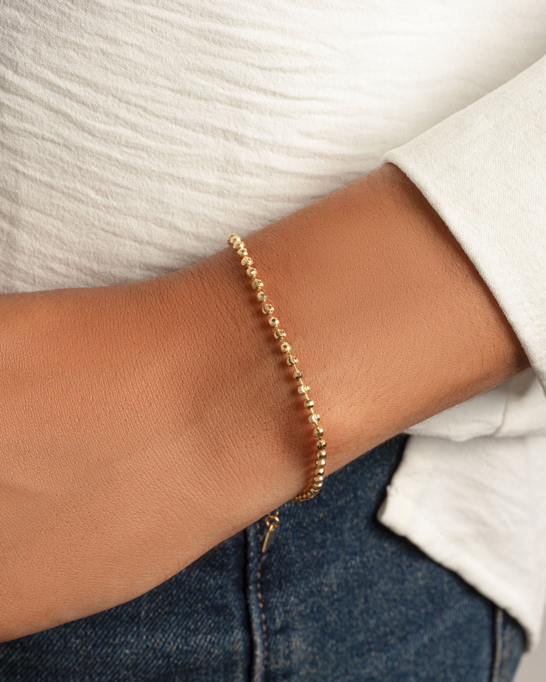 Gold beaded bracelet on model 