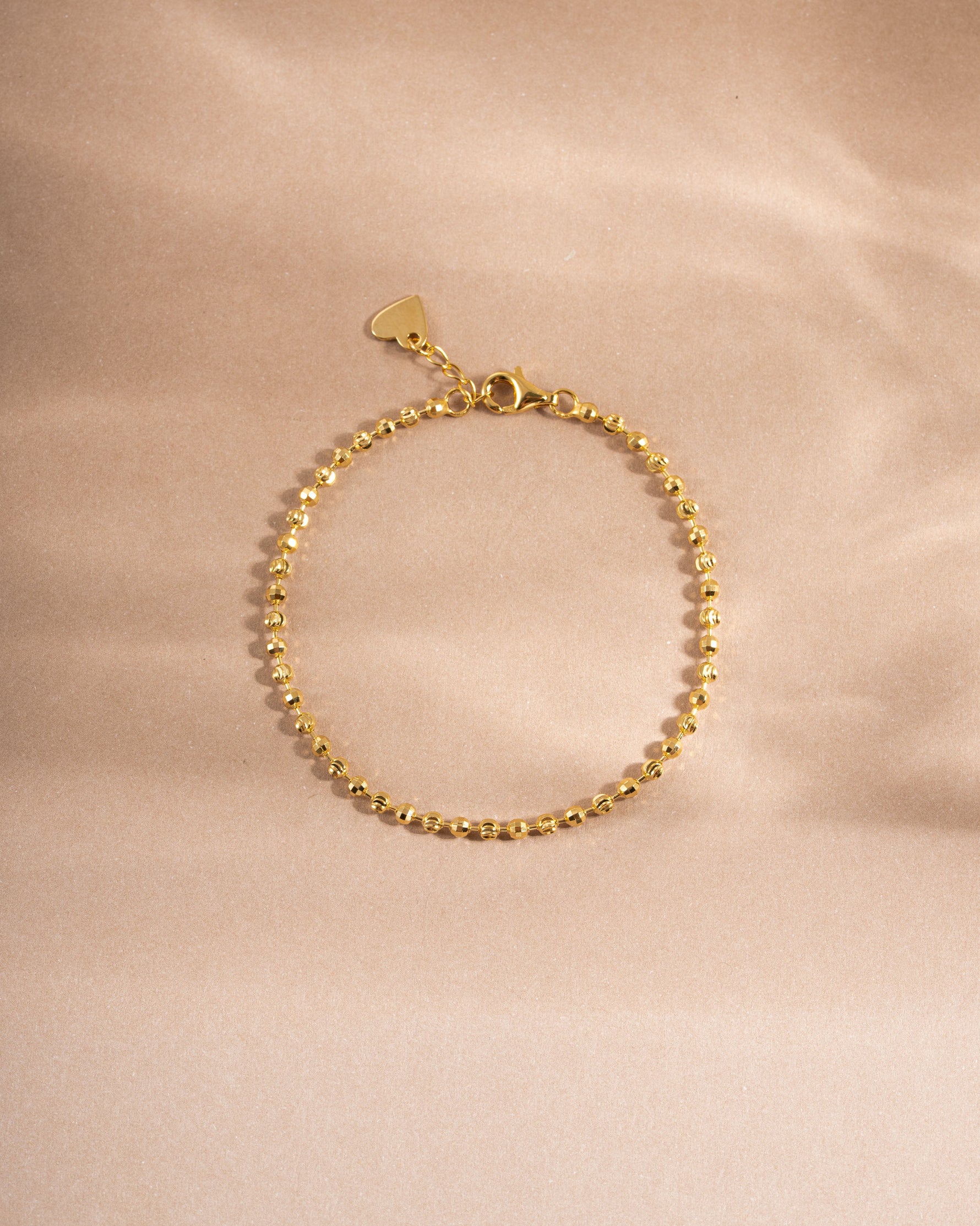 Gold adjustable minimalist bracelet on neutral background