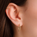Model wearing simple delicate twisted hoop earrings
