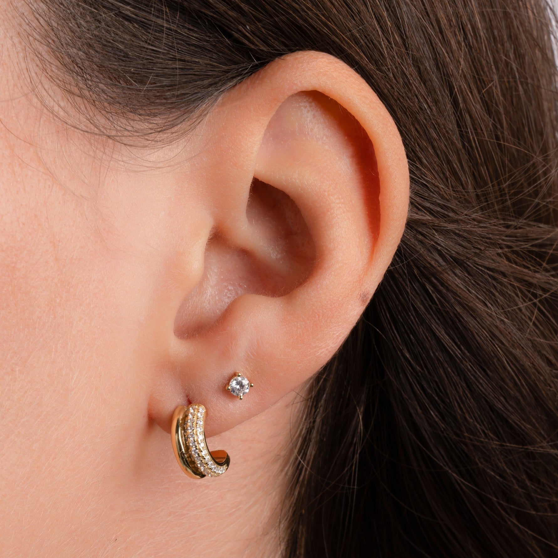model wearing small hoop earrings featuring a gold hoop with cubic zirconia stones