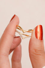 Model holding stackable chevron ring set in gold. 