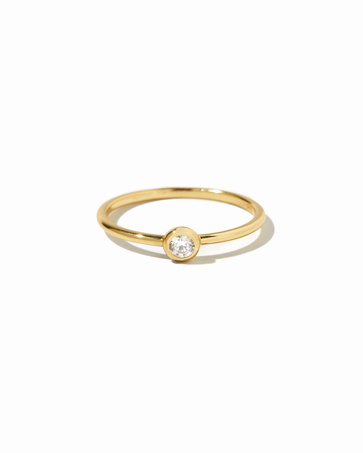 closeup image of gold solitaire stacking ring 