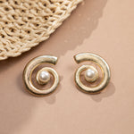 closeup image of drop statement earrings featuring spiral earring design and a freshwater pearl