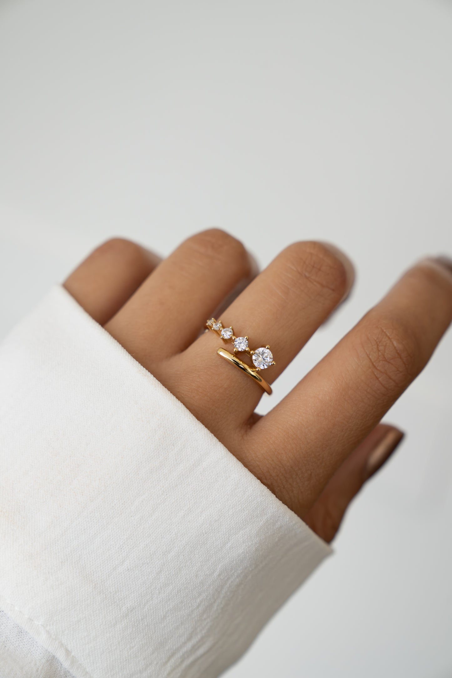 Sami Jewels 14k Gold Plated Bypass Ring with 5 Gradient CZ Stones on model's finger against a white background