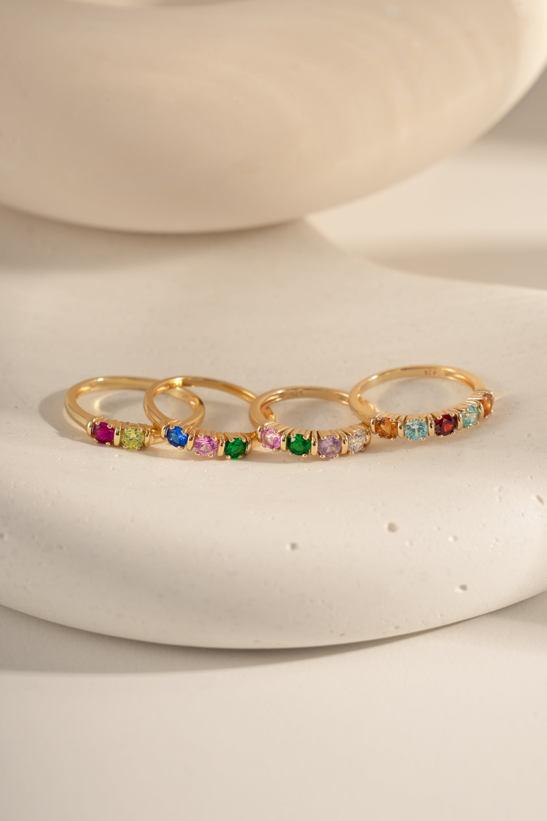 closeup image of closeup birthstone rings ranging from 2 stone, 3 stone, 4 stone and 5 stone