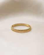 Gold ring on a beige fabric background