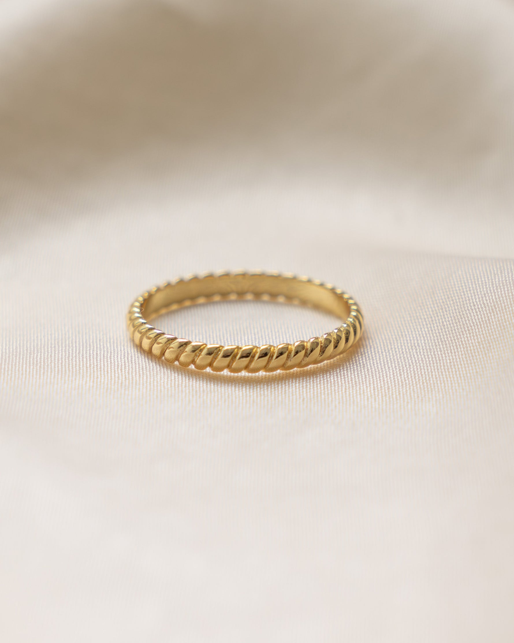 Gold ring on a beige fabric background