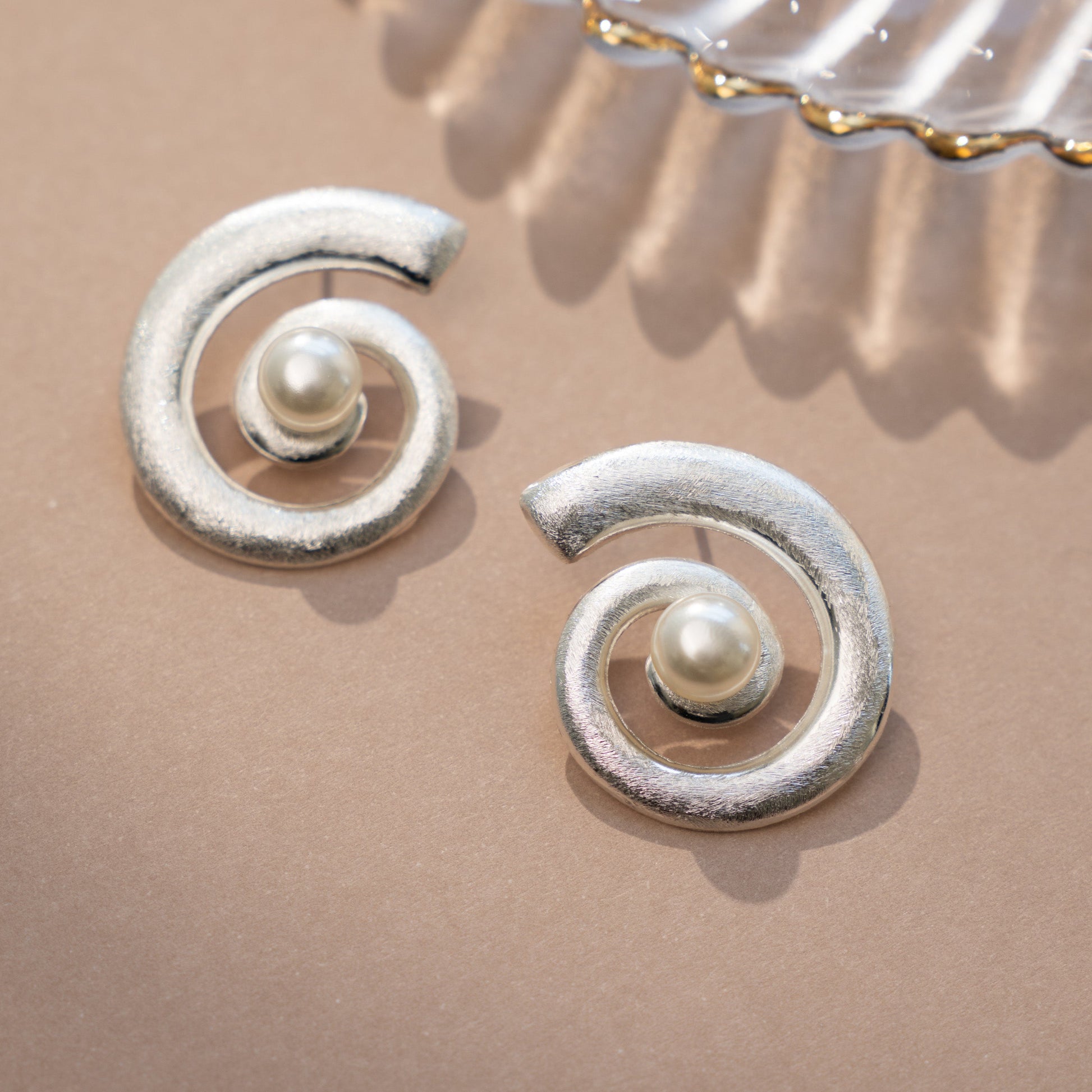 closeup image of pearl earrings featuring a boho earring spiral earring design