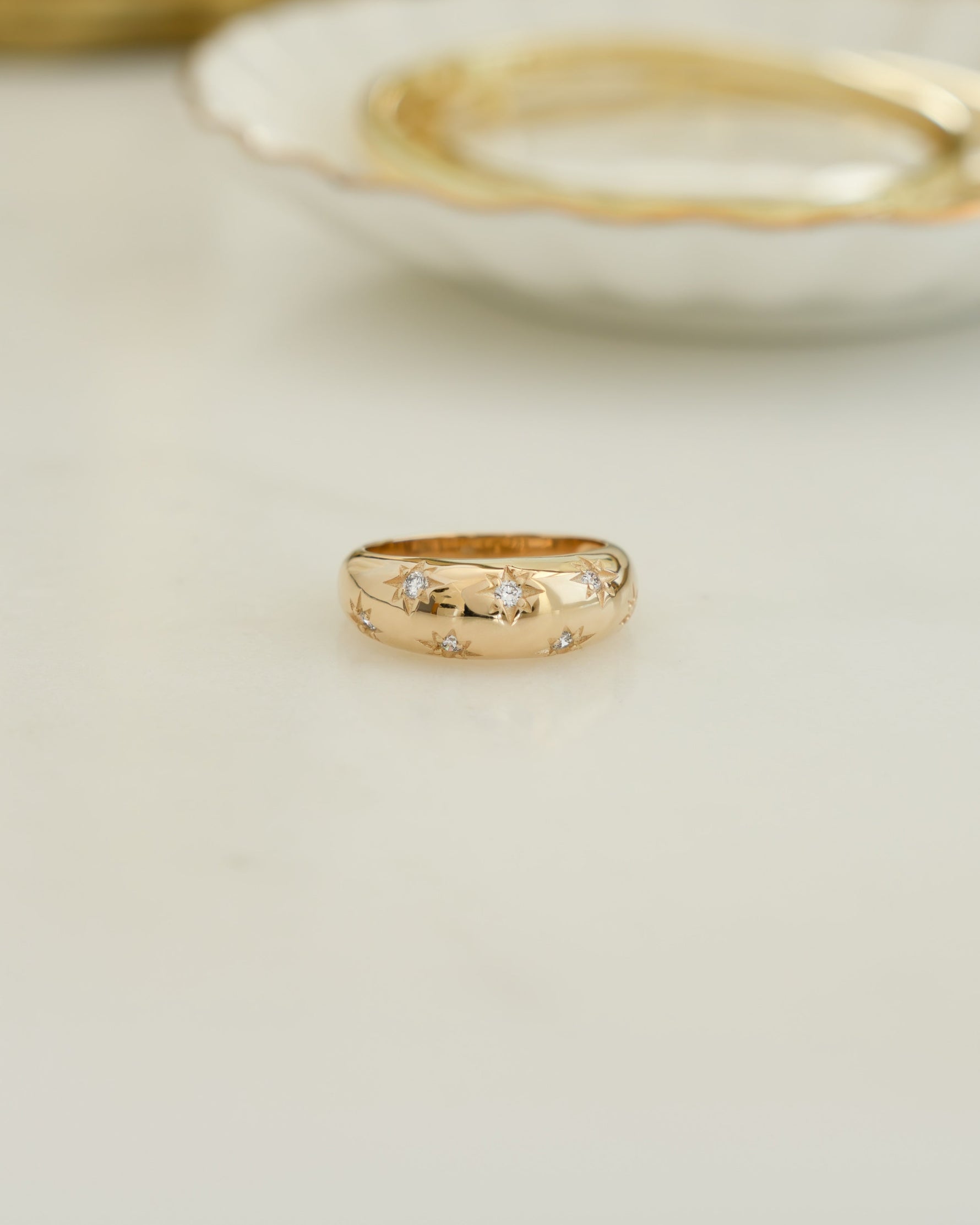 Closeup image of statement jewelry featuring a star dome gold statement ring