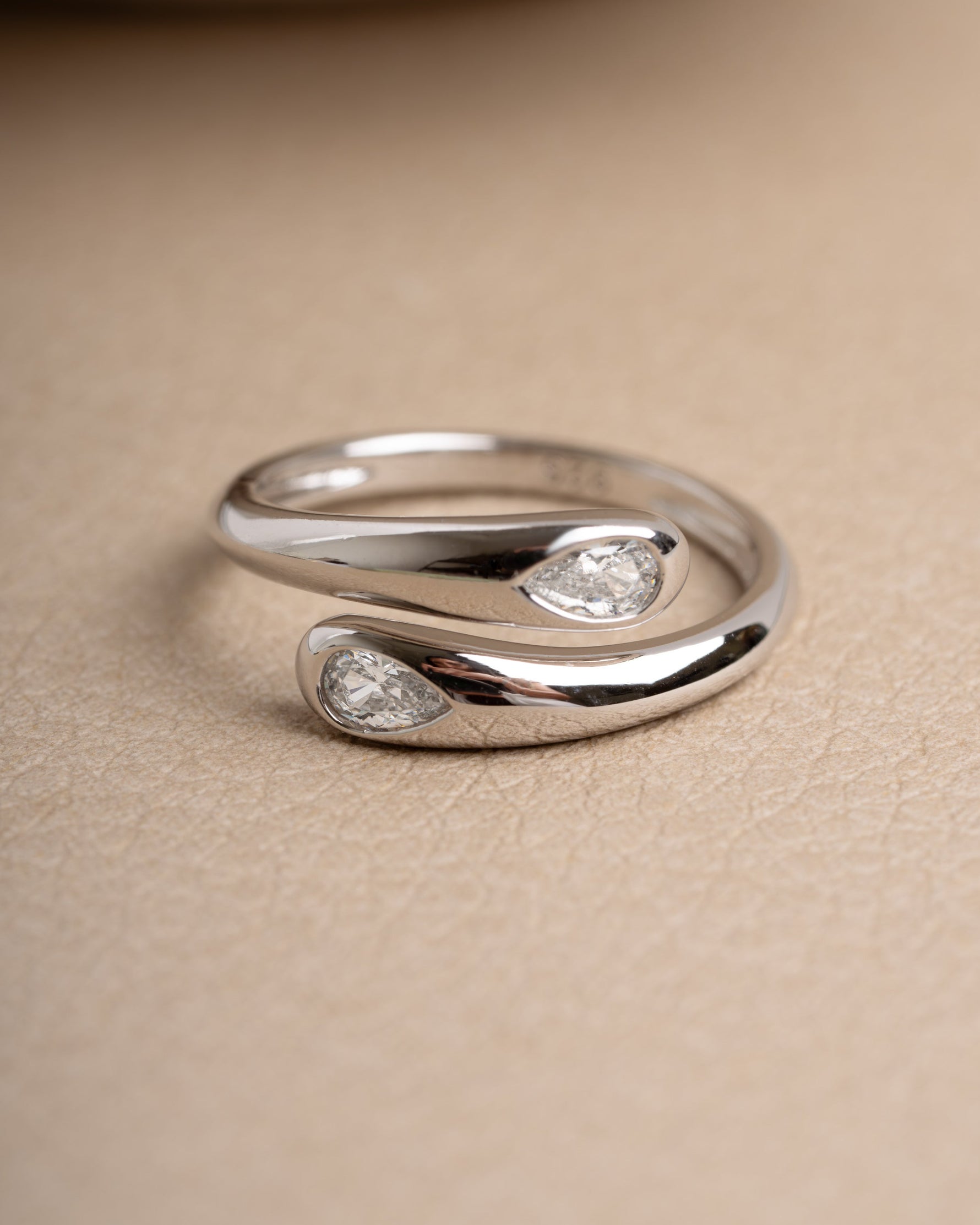 Sterling silver diamond ring on a beige surface