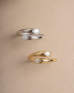 Sterling silver diamond ring and gold stackable ring on a beige surface