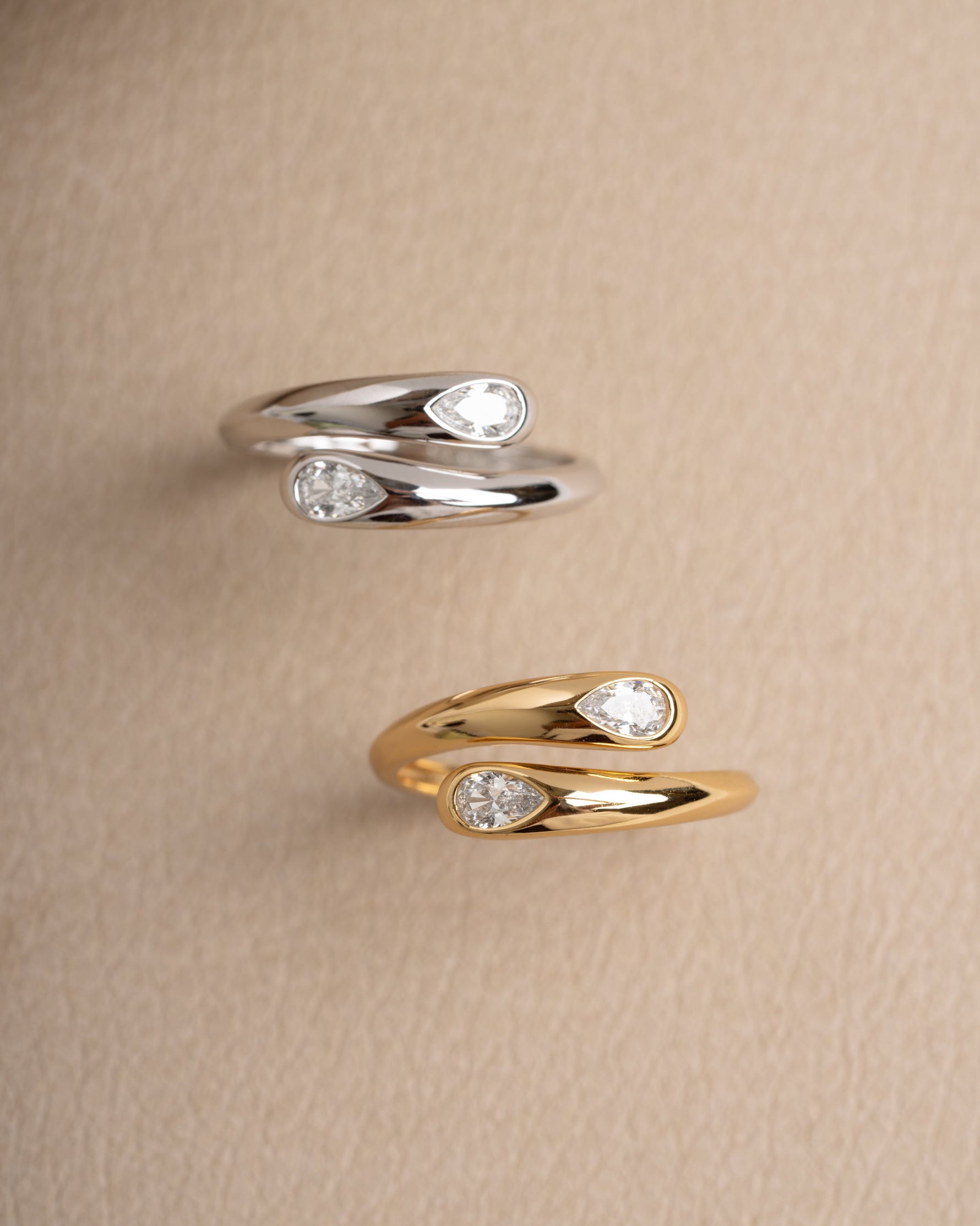 Sterling silver diamond ring and gold stackable ring on a beige surface
