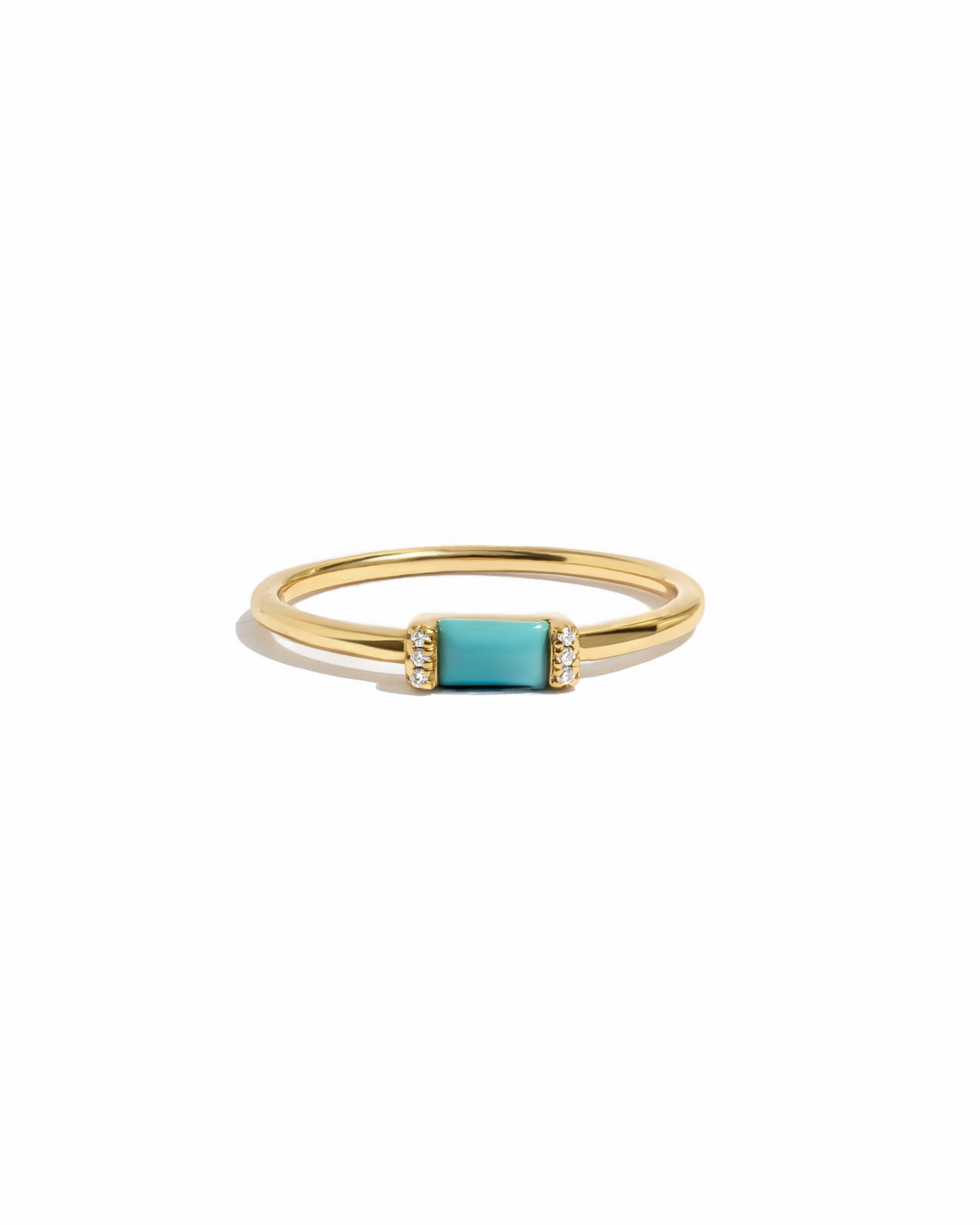 Gold ring with a turquoise gemstone on a white background
