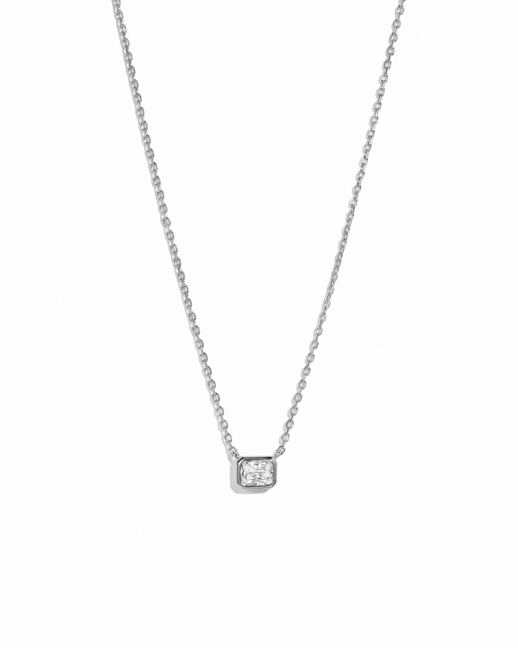 Sterling silver diamond bezel pendant necklace on delicate chain against a white background