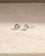 Pair of silver stud earrings on a beige marble surface perfect wedding jewelry or gift for her