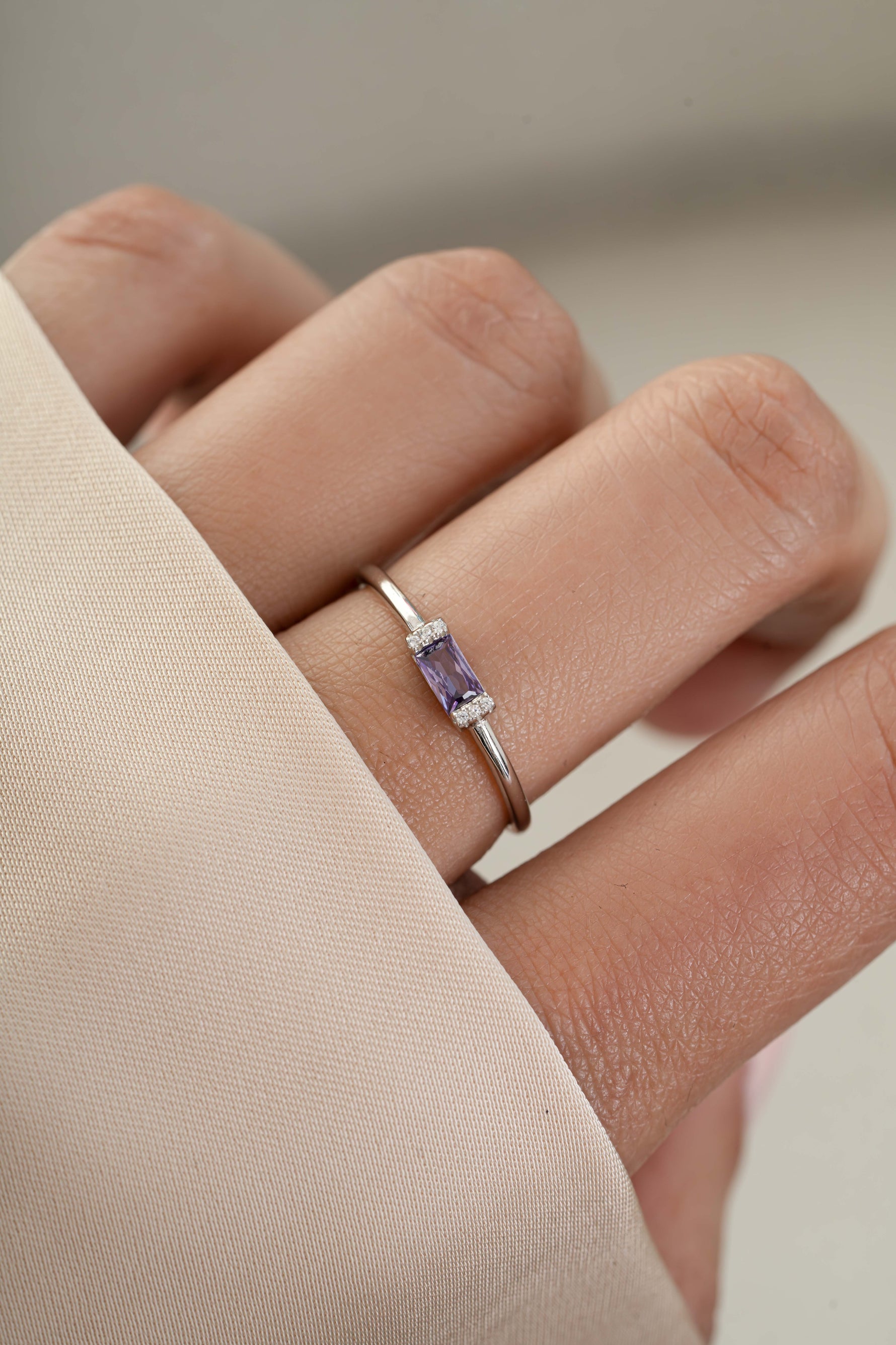 Model wearing sterling silver dainty stackable birthstone ring