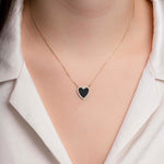 Model wearing a dainty black onyx heart necklace, styled solo with a casual outfit for a chic minimalist look.