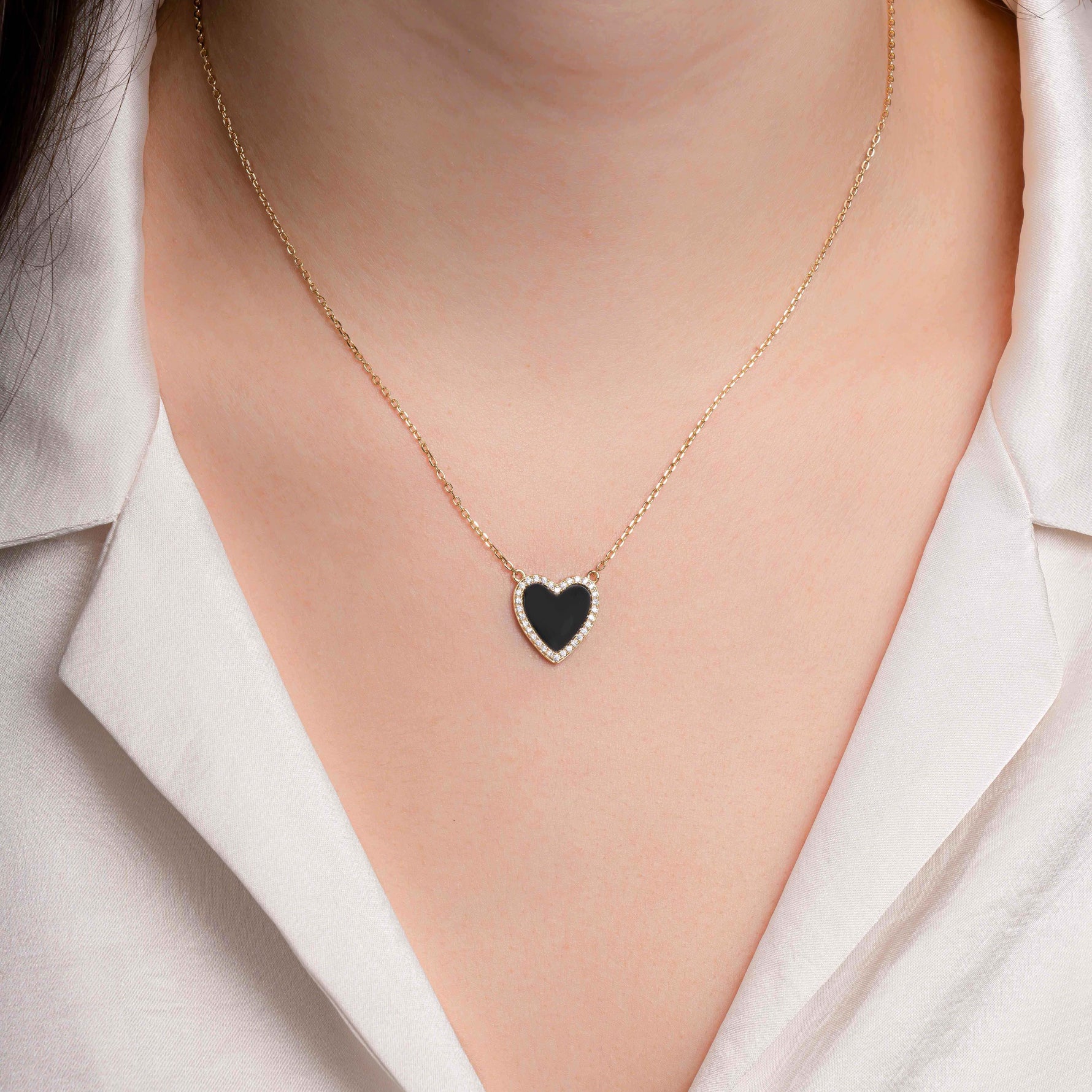 Model wearing a dainty black onyx heart necklace, styled solo with a casual outfit for a chic minimalist look.