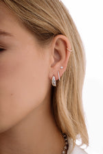 Model wearing sterling silver celestial hoops a, diamond hoop earring and a diamond stud earring