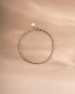 Silver beaded bracelet on beige background