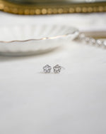 Silver flower earrings on a white surface 