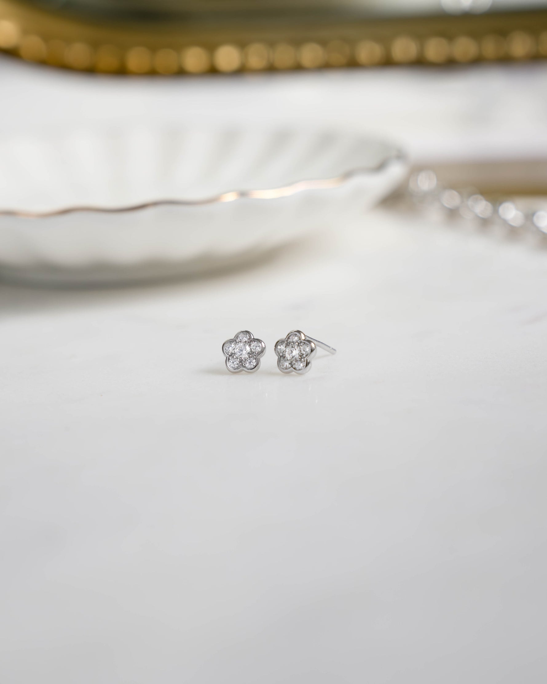 Silver flower earrings on a white surface 