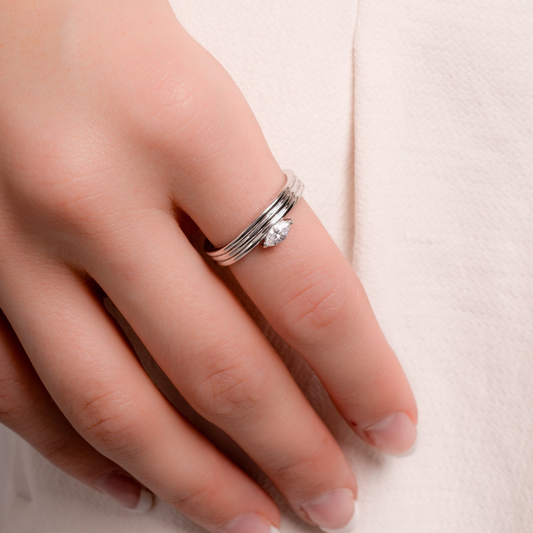 model wearing dainty ring featuring marquise cut stone