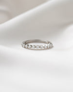 Sterling silver half eternity ring on a silk background  