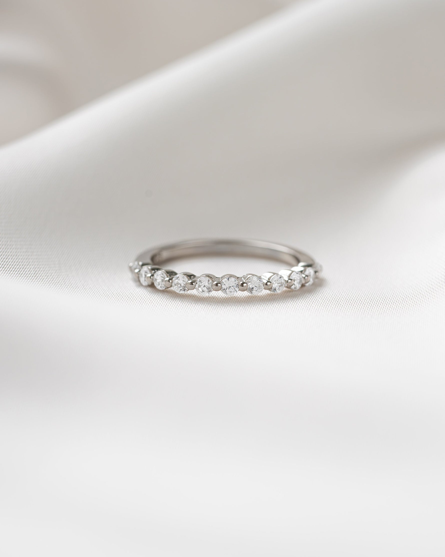 Sterling silver half eternity ring on a silk background  