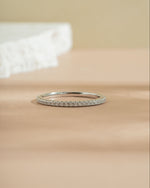Sterling silver diamond eternity band on beige surface