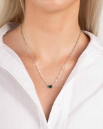 Model wearing emerald gemstone necklace with silver chain