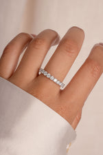 Model wearing engagement style wedding diamond band in silver. 