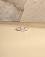Closeup image of sterling silver bezel set dome ring on beige background