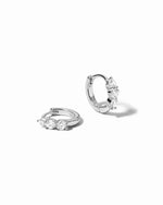 Pair of silver hoop earrings with cubic zirconia gemstones on a white background