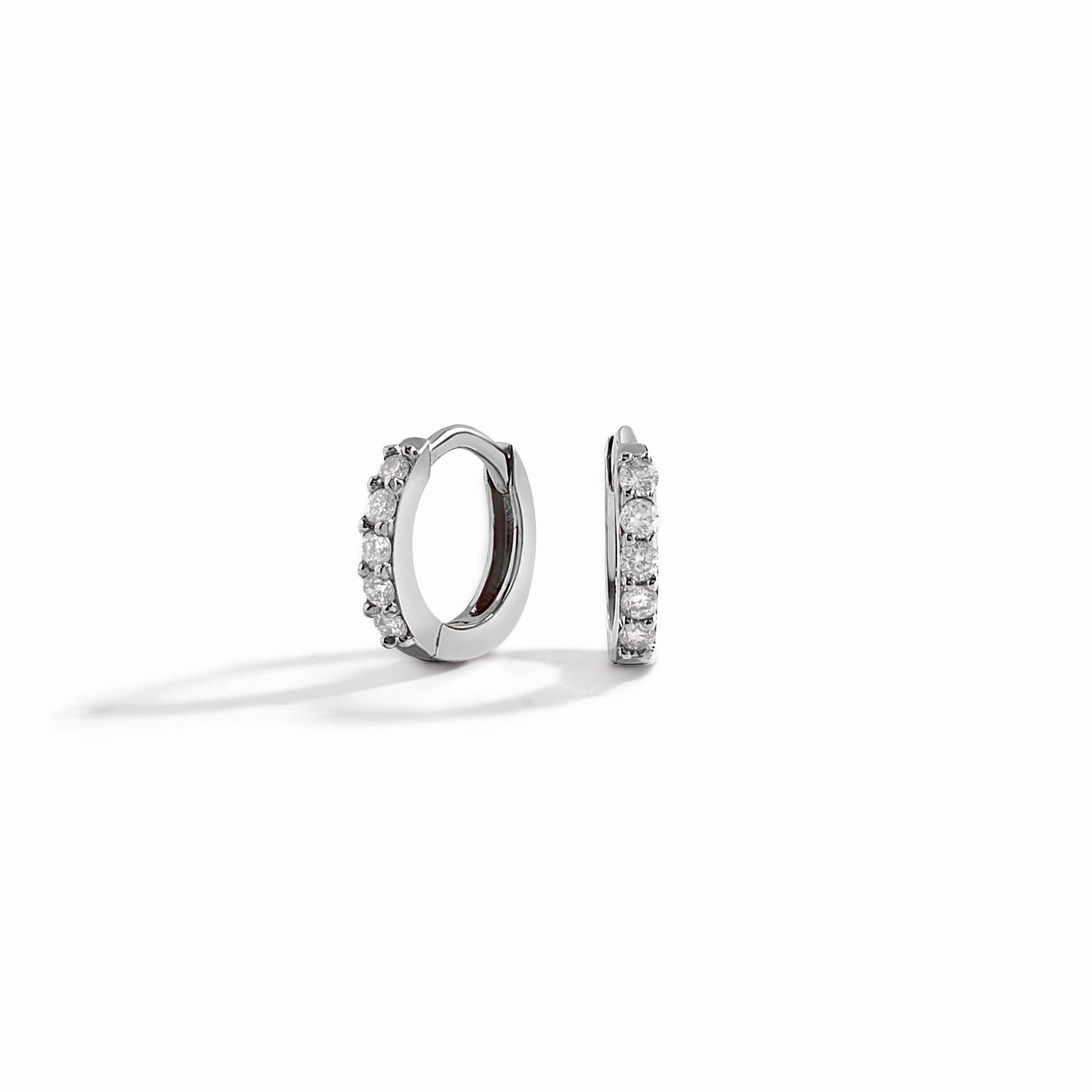 closeup image of sterling silver mini huggie hoop earrings