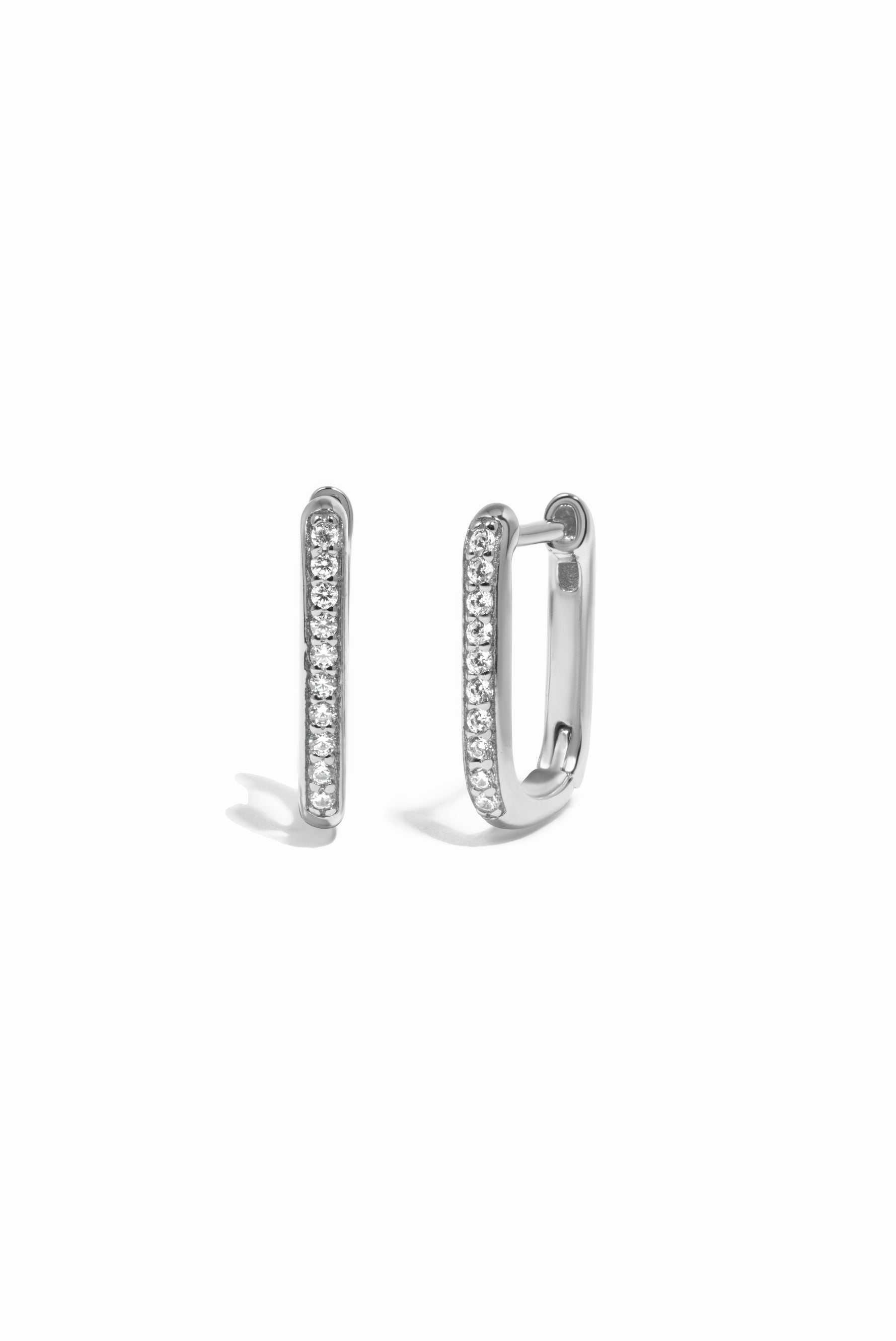 Pair of silver hoop earrings with a square hoop design and pave stones on a white background
