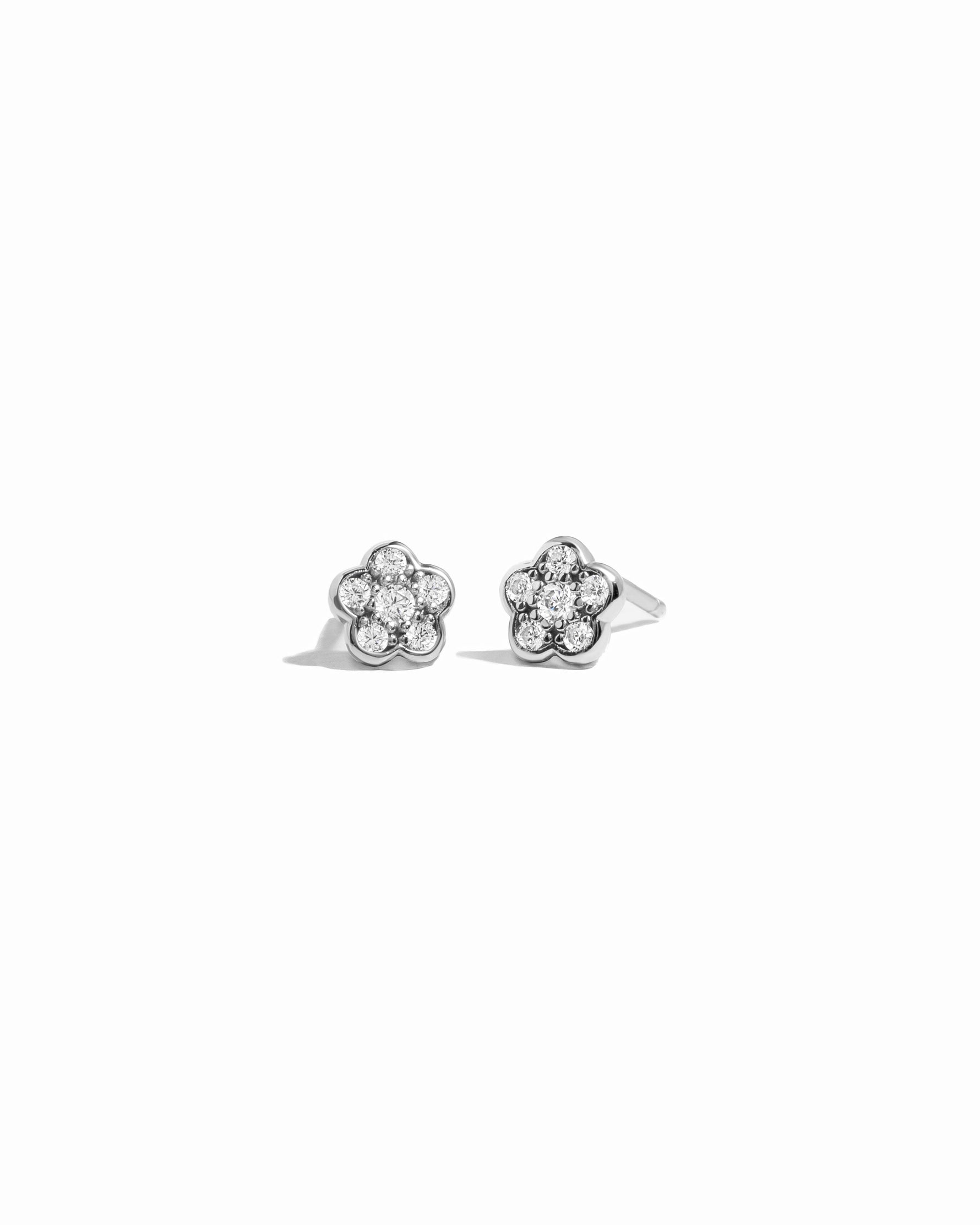 Closeup image of sterling silver stud earrings with a floral earring design on a white background