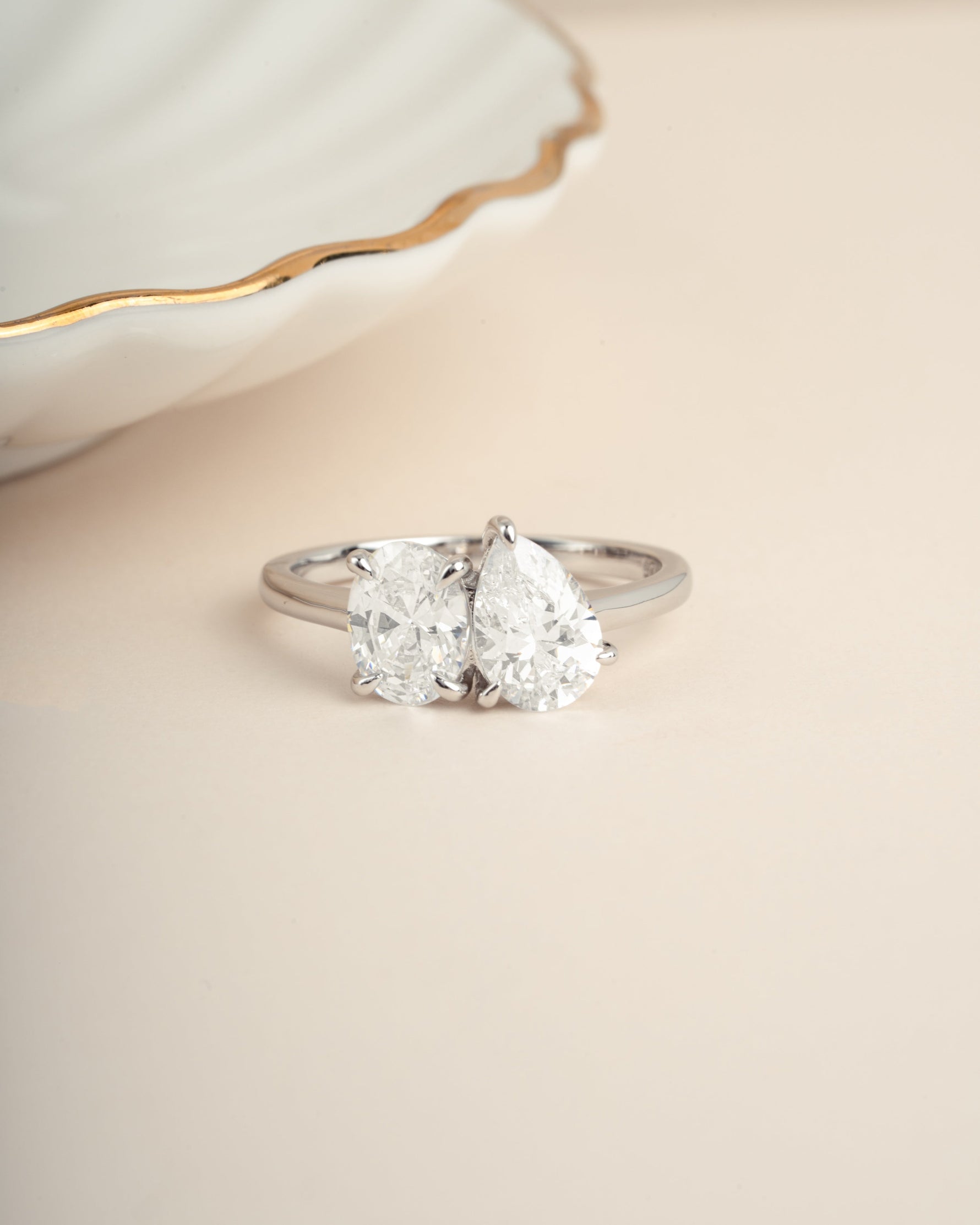 Sterling silver diamond ring on a beige background