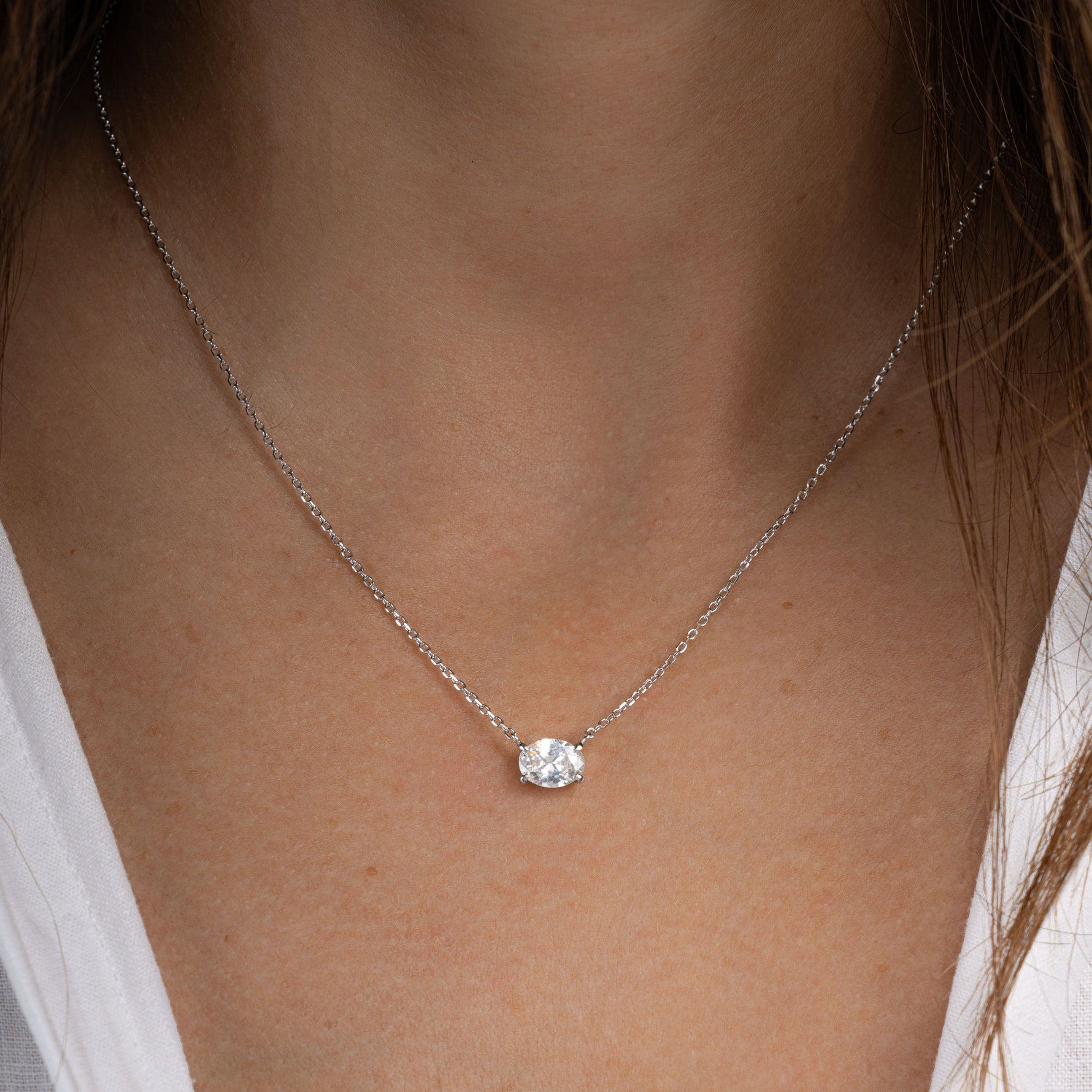 Model wearing minimalist necklace with diamond pendant