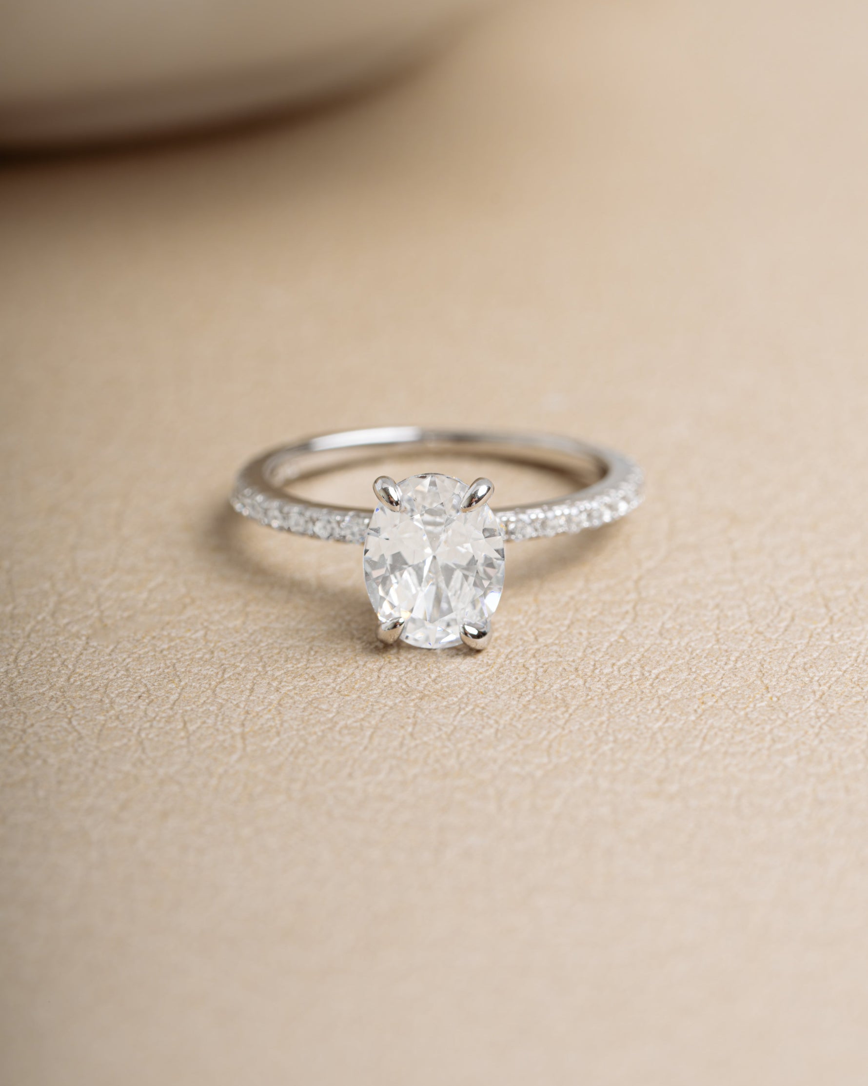 Sterling silver bridal jewelry featuring a promise ring on a beige background