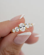 Model showcasing gold oval promise ring with oval and round cubic zirconia stones