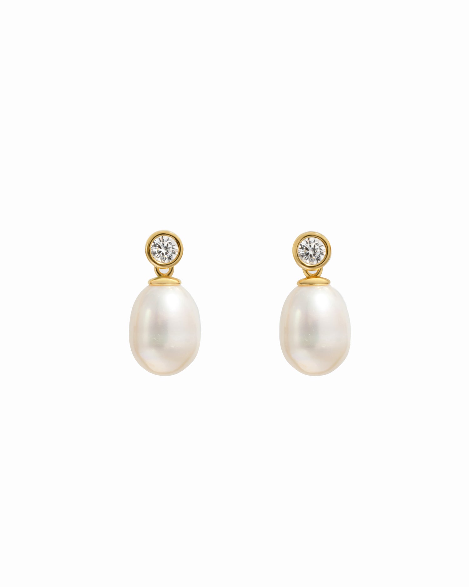 closeup image of gold drop earrings with a freshwater pearl and cubic zirconia bezel-set stone