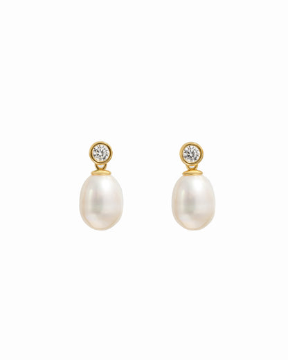 closeup image of gold drop earrings with a freshwater pearl and cubic zirconia bezel-set stone
