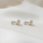 side view of sterling silver freshwater pearl dangle drop stud earrings with a bezel set cubic zirconia stone