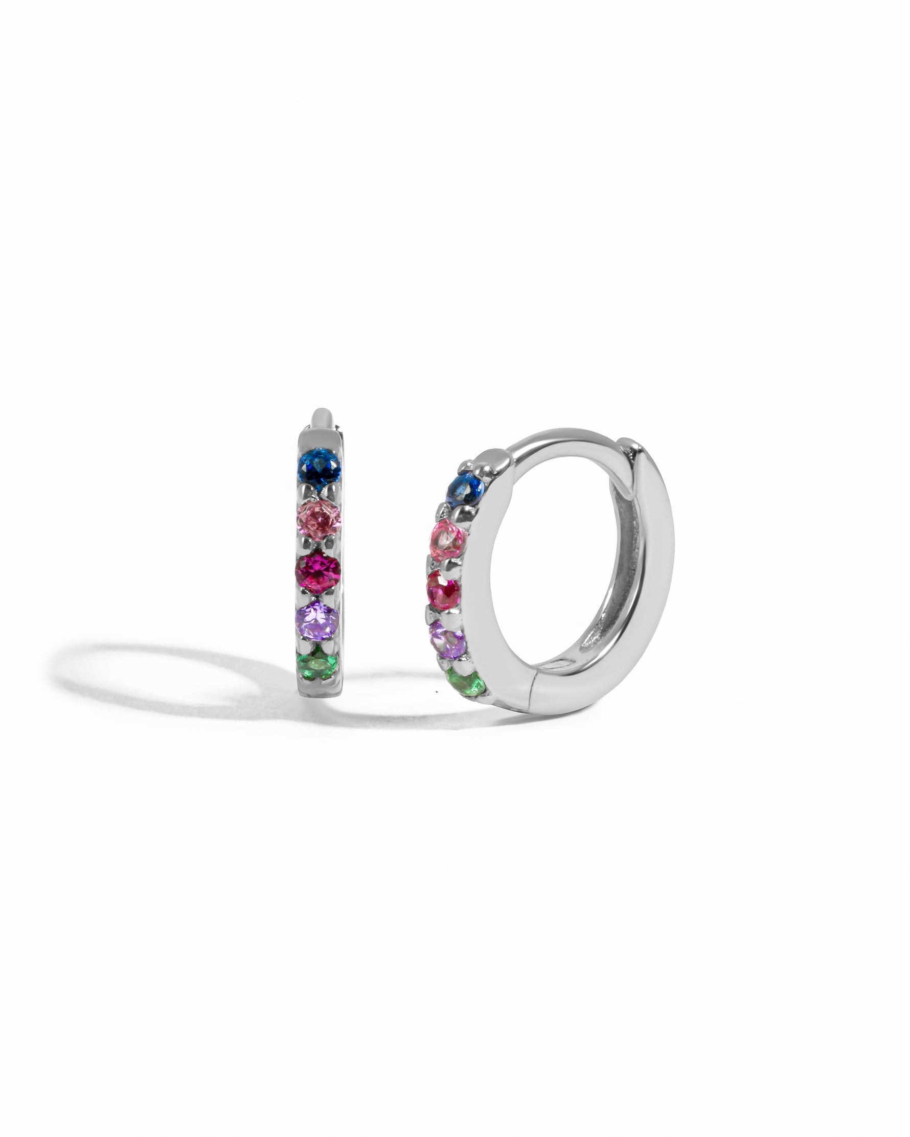 Silver hoop earrings with colorful gemstones on a white background
