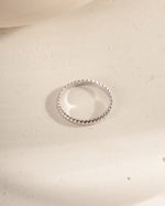Silver ring on a textured beige surface