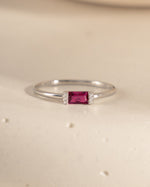 closeup image of birthstone jewelry featuring a ruby baguette ring