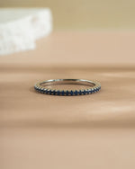 Sterling silver ring band with sapphire gemstones on a beige surface