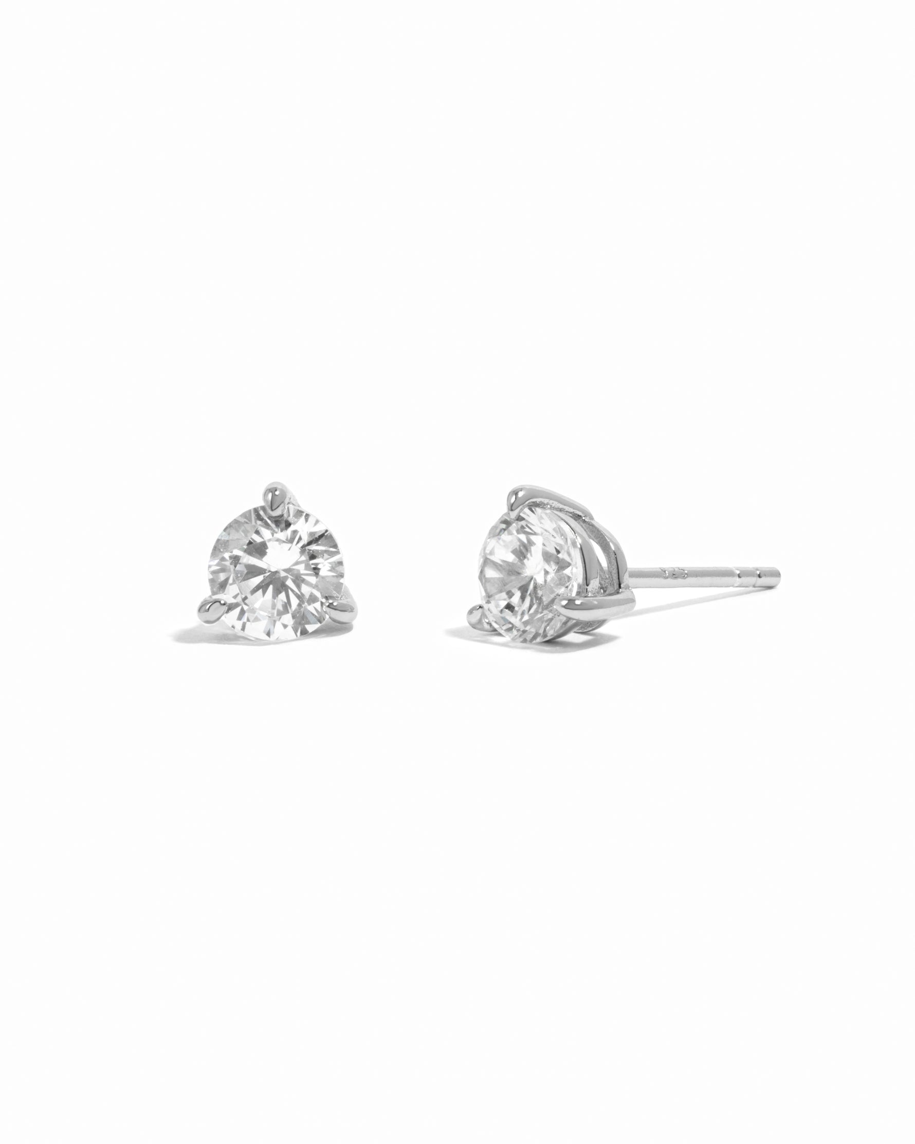 Silver diamond stud earrings on a white background